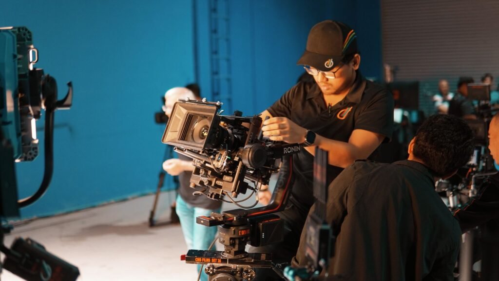 Film crew setting up professional camera equipment in a studio for shooting.