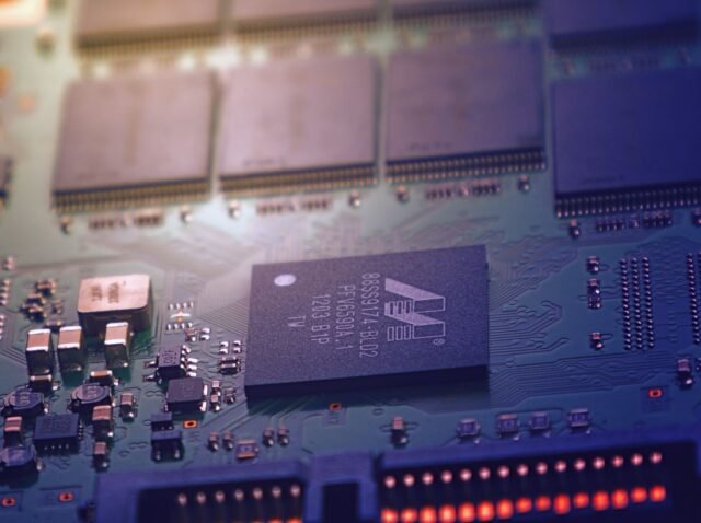 Detailed image of an electronic circuit board showing microchips and intricate wiring in a modern technological setting.