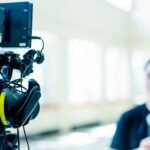Professional video camera setup focusing on an interview with blurred subject in the background.